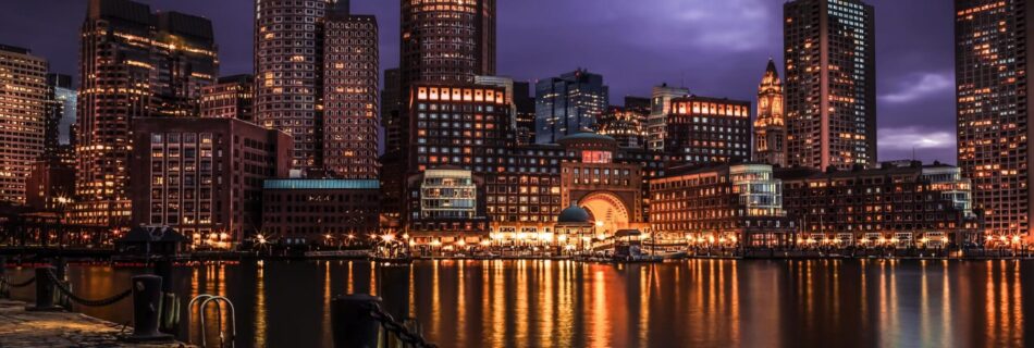 Image of Boston Skyline, over the water at night.