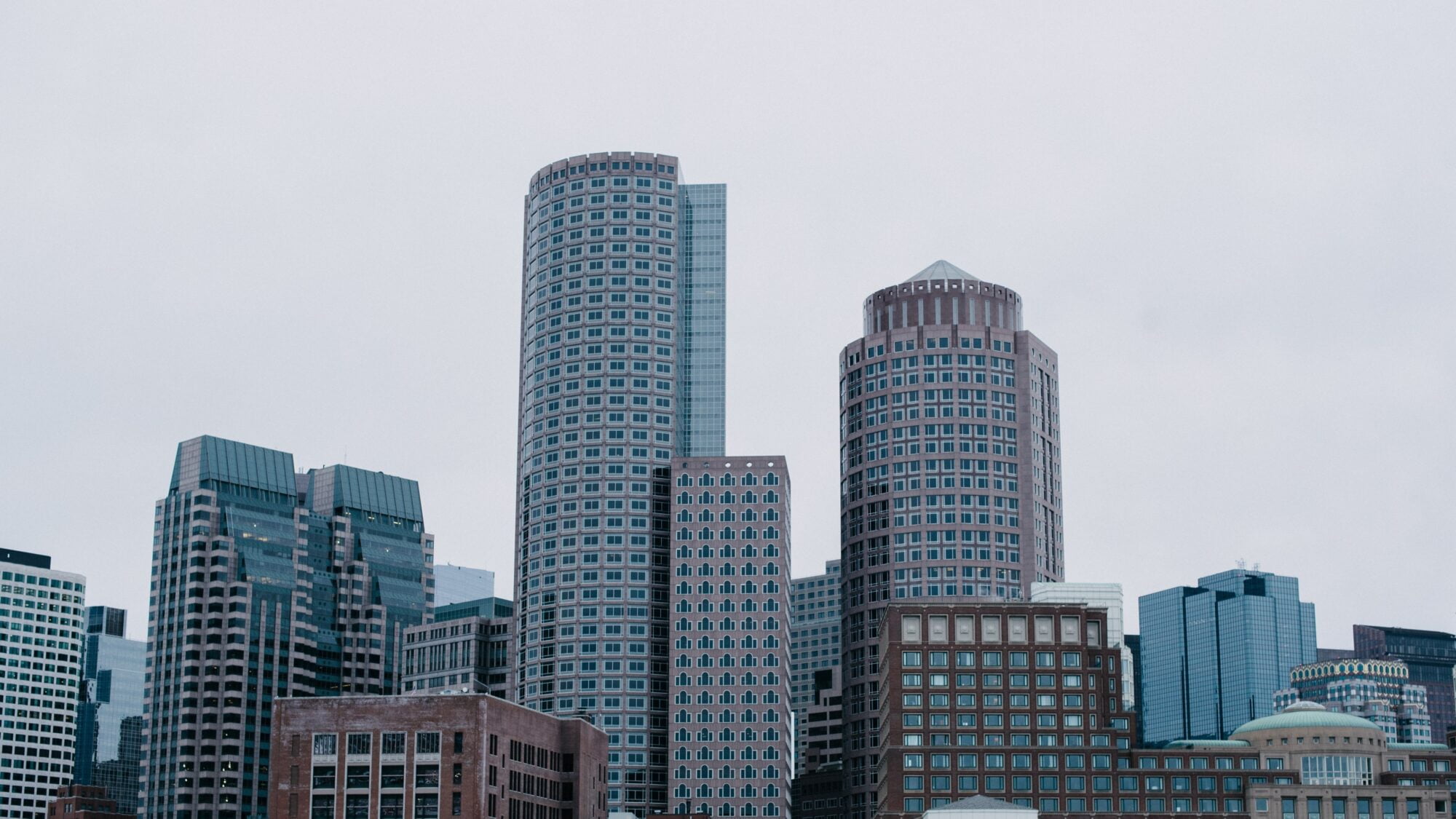 Image of the Boston Skyline. Blue and Brown Buildings on a cloudy Day.
